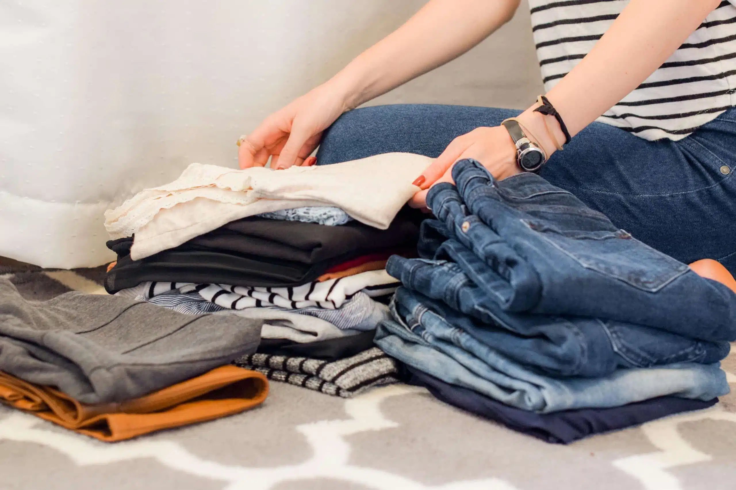 Woman folding clothes. Photo by Sarah Brown on Unsplash.